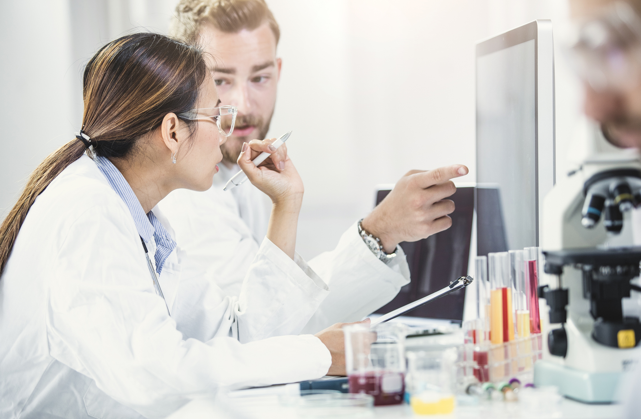 Scientists Looking At Computer Monitor And Discussing